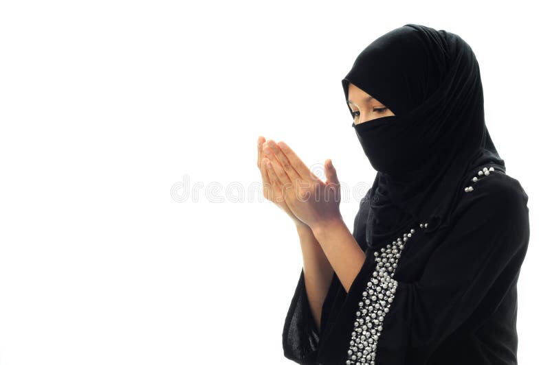 A muslim women pray looking down from side wide