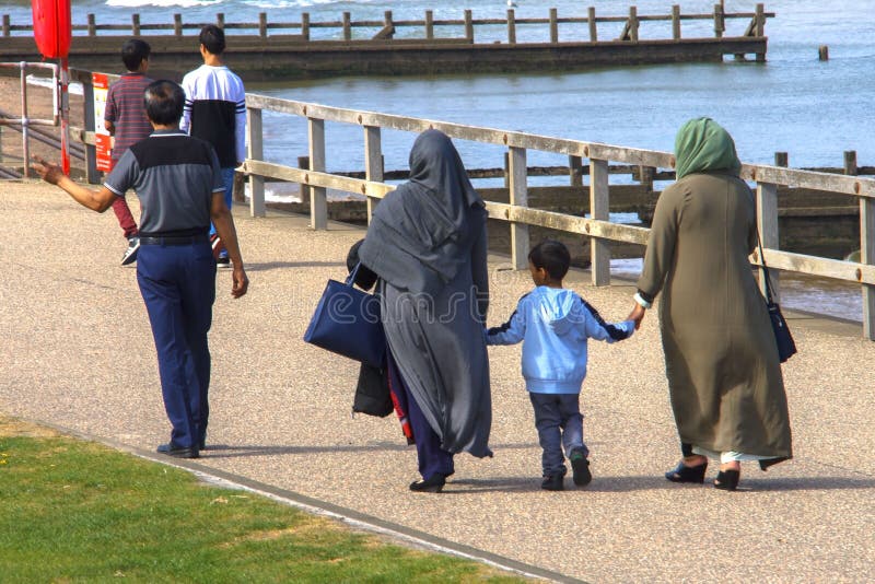 Muslimsk familj som går på stranden fotografering för bildbyråer Muslimsk familj som går på stranden fotografering för bildbyråer