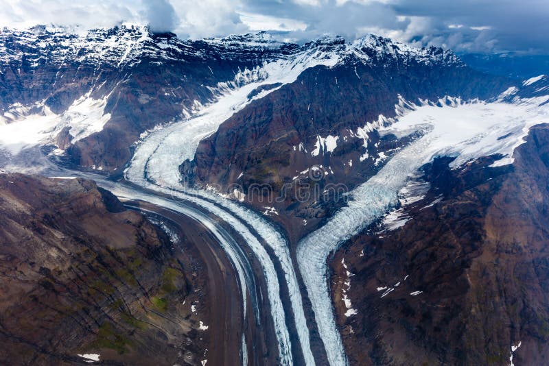 Muster des Schnees bedeckte Berge und schmelzende Gletscher in Alaska mit einer Kappe stockfotografie