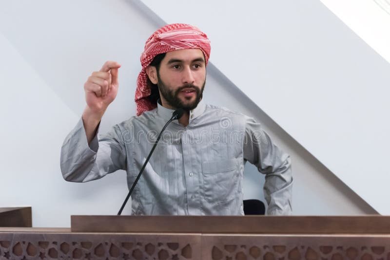 Musulmán el joven imam árabe tiene un discurso en la oración del viernes por la tarde en la mezquita. los musulmanes se han reunid fotografía de archivo libre de regalías