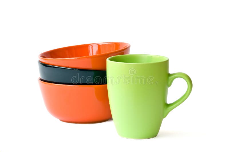 Red and black bowls and green mug on the white background. Red and black bowls and green mug on the white background