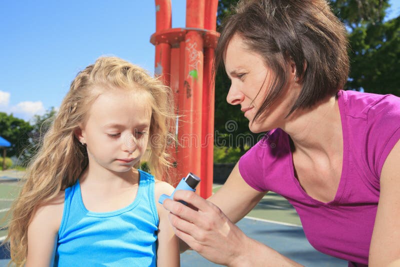 Mutter, die Inhalator mit ihrer asthmatischen Tochter verwendet stockfotografie