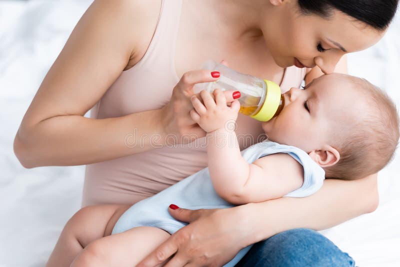 Mutter, die nette Säuglingssohnwann nährt stockfoto