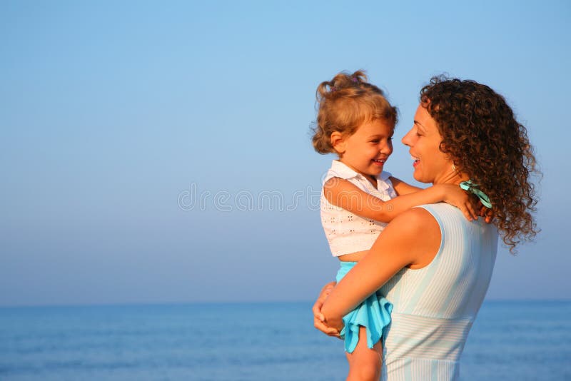Mutter hält Kind an den Händen des Randes von Meer lizenzfreie stockfotos Mutter hält Kind an den Händen des Randes von Meer lizenzfreie stockfotos