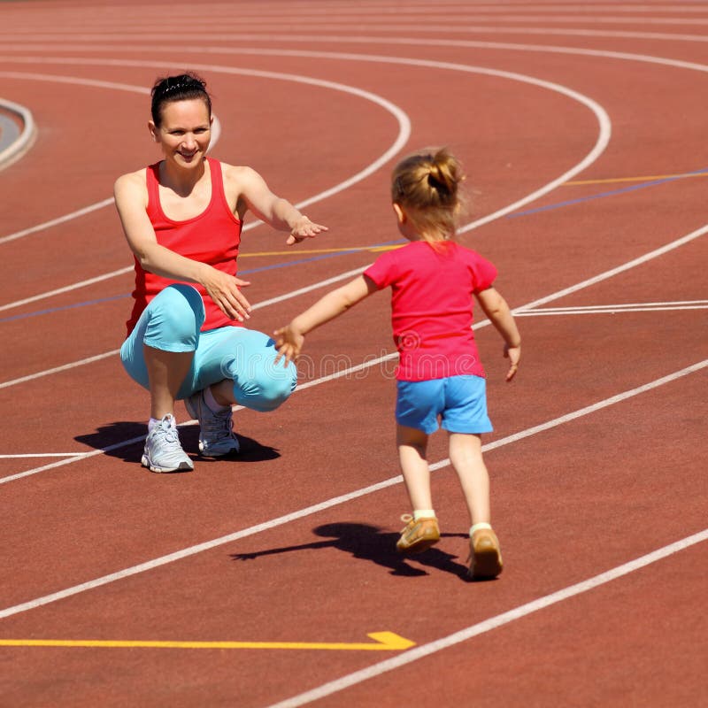 Mutter & kleine Tochter läuft um das Stadion. lizenzfreie stockbilder