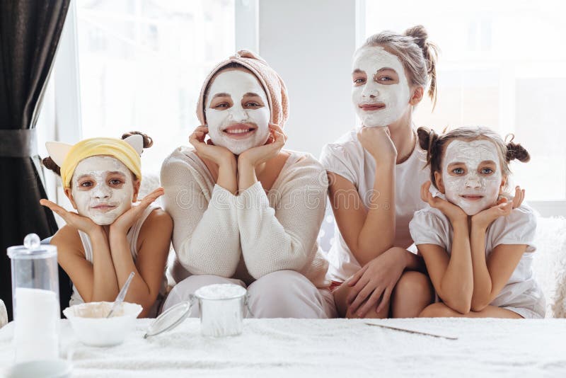 Mutter mit ihren Töchtern, die LehmGesichtsmaske machen stockfoto Mutter mit ihren Töchtern, die LehmGesichtsmaske machen stockfoto
