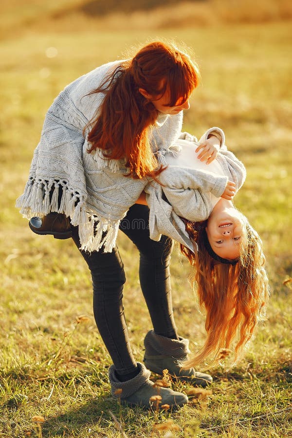 Mutter mit kleinen Tochter, die auf einem Herbstgebiet spielt lizenzfreie stockfotos
