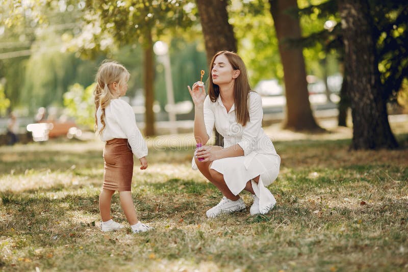 Mutter mit kleiner Tochter spielt in einem Sommerpark lizenzfreies stockfoto