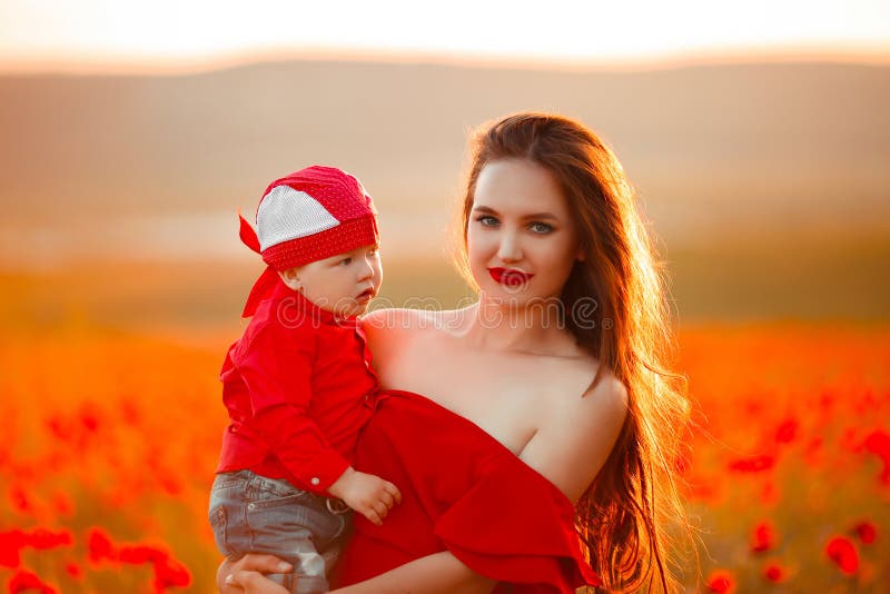 Mutter mit Sohn in den Mohnblumen, die das Leben bei Sonnenuntergang genießen Glückliche Familie stockfotos Mutter mit Sohn in den Mohnblumen, die das Leben bei Sonnenuntergang genießen Glückliche Familie stockfotos