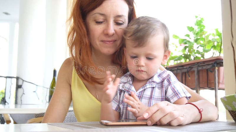 Mutter mit Sohngebrauch ein Smartphone für Internet stock video