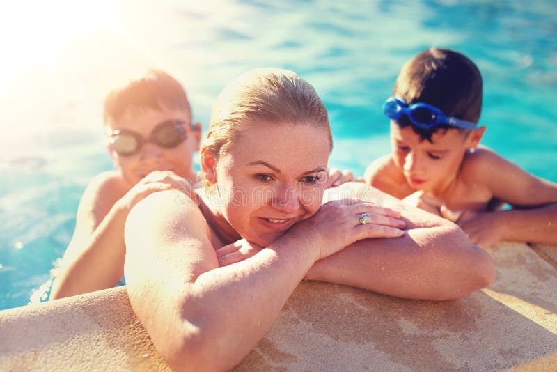 Mutter am Rand des Swimmingpools mit Söhnen stockbilder Mutter am Rand des Swimmingpools mit Söhnen stockbilder