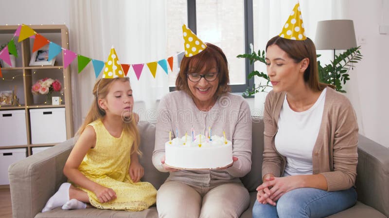 Mutter, Tochter, Großmutter mit Geburtstagskuchen