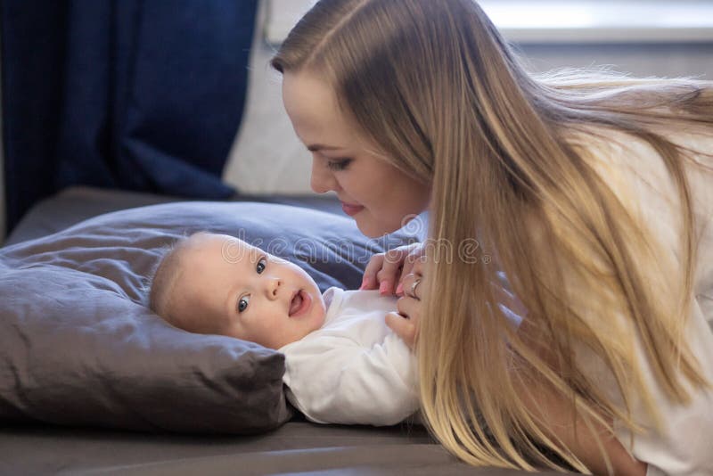 Mutter und Baby auf Bett lizenzfreie stockbilder Mutter und Baby auf Bett lizenzfreie stockbilder