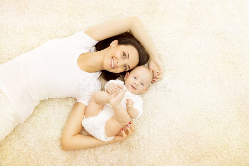 Mutter und Baby, glückliches Familien-Porträt, Mutter mit Kind auf Teppich