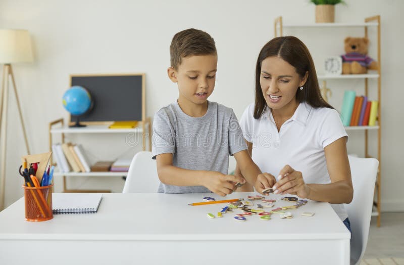 Mutter und ihr kleiner Sohn zu Hause lernen Mathematik spielen mit Zahlen Rätsel. stockfotografie