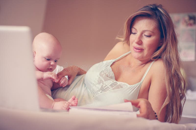 Mutter und ihr kleines Baby zu Hause Mutter, die zu Hause arbeitet stockfotos Mutter und ihr kleines Baby zu Hause Mutter, die zu Hause arbeitet stockfotos