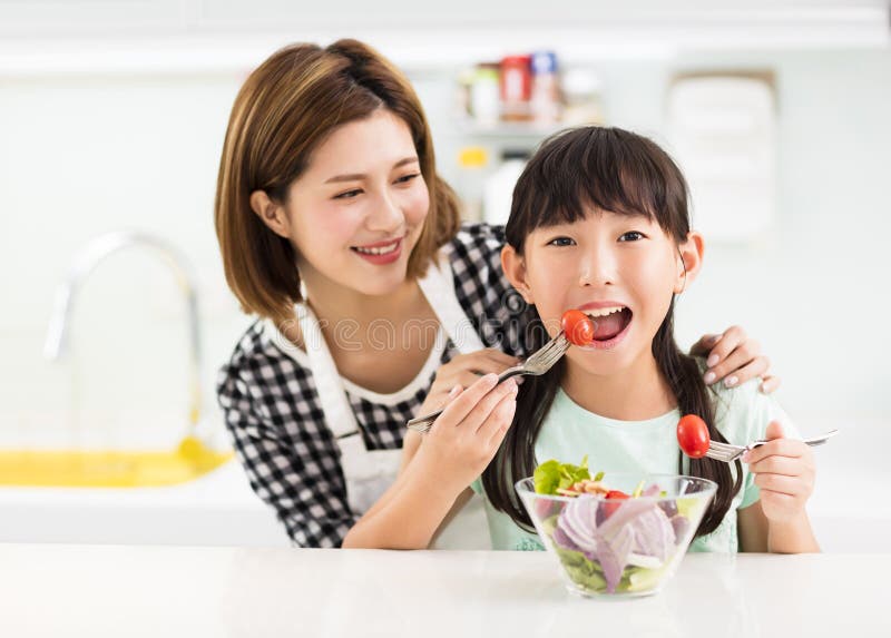 Mutter und Kind in der Küche Salat essend stockfoto Mutter und Kind in der Küche Salat essend stockfoto