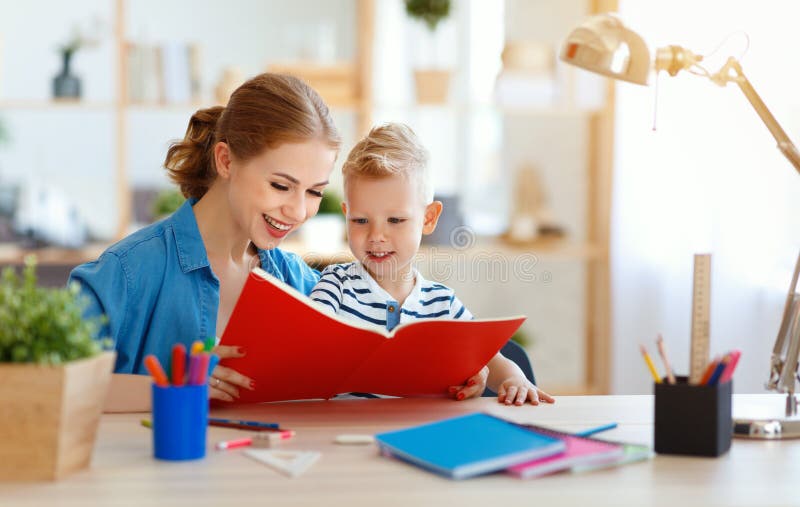Mutter- und Kindersohn, der Hausarbeitschreiben tut und zu Hause liest lizenzfreie stockfotos Mutter- und Kindersohn, der Hausarbeitschreiben tut und zu Hause liest lizenzfreie stockfotos