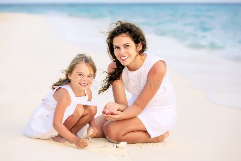 Mutter und kleine Tochter, die auf dem Strand auf Malediven an den Sommerferien spielen stockbild Mutter und kleine Tochter, die auf dem Strand auf Malediven an den Sommerferien spielen stockbild