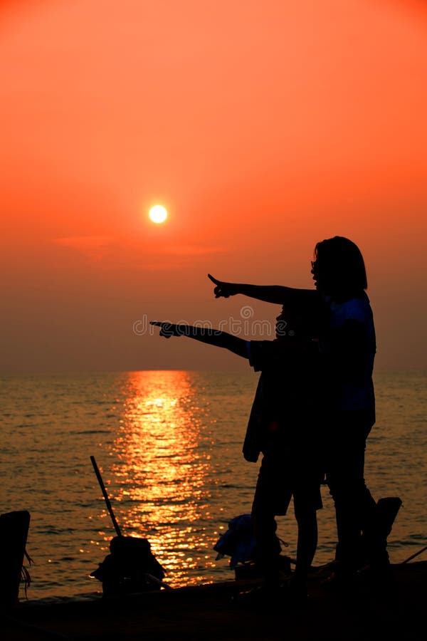 Mutter und Sohn in einem tiefen Moment der Liebe während des Sonnenuntergangs am Strand lizenzfreie stockfotos Mutter und Sohn in einem tiefen Moment der Liebe während des Sonnenuntergangs am Strand lizenzfreie stockfotos