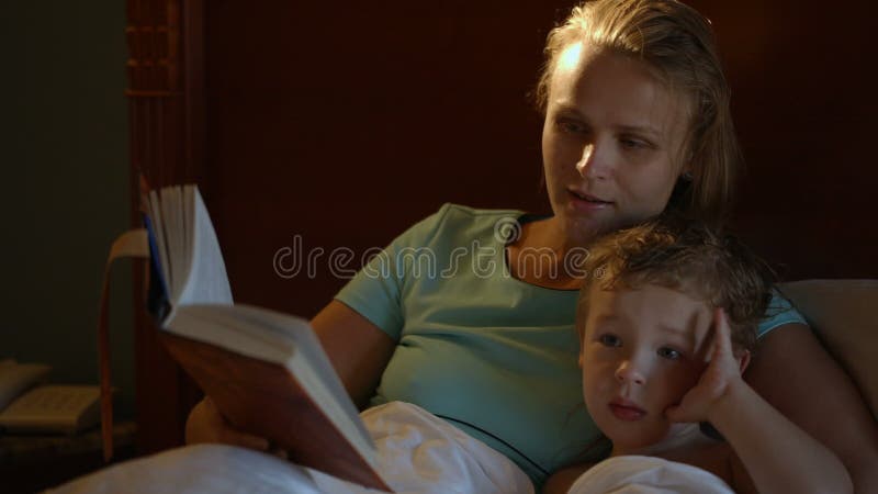 Mutter und Sohn im Bett mit Buch stock video