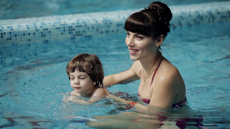 Mutter und Sohn im Pool Junge Mutter unterrichtet ihren 3-jährigen Sohn zu schwimmen