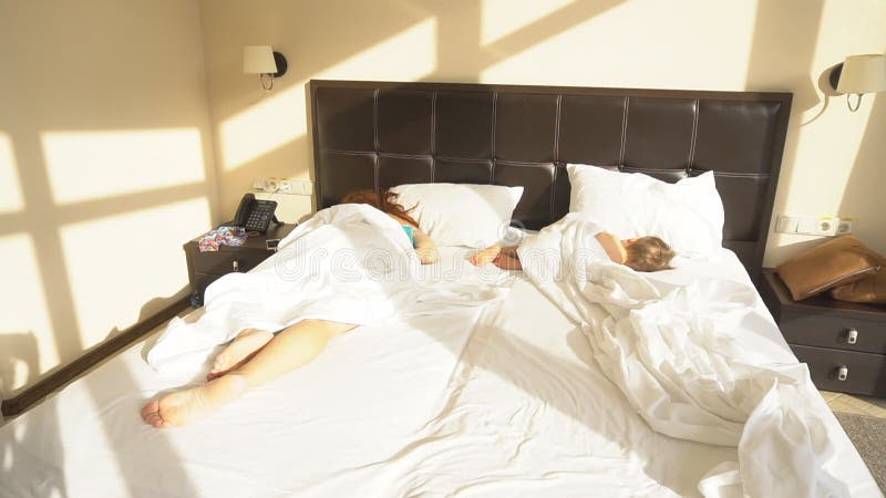 Mutter und Sohn schlafen morgens im Bett an stock video footage