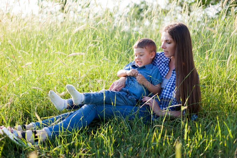 Mutter- und Sohnporträt gegen grüne Baumfamilie lizenzfreie stockfotos Mutter- und Sohnporträt gegen grüne Baumfamilie lizenzfreie stockfotos