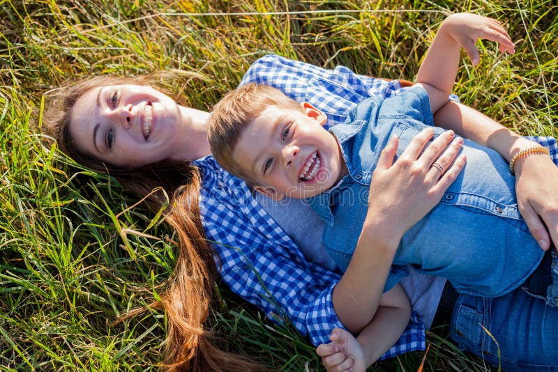 Mutter- und Sohnporträt gegen grüne Baumfamilie stockfotografie Mutter- und Sohnporträt gegen grüne Baumfamilie stockfotografie
