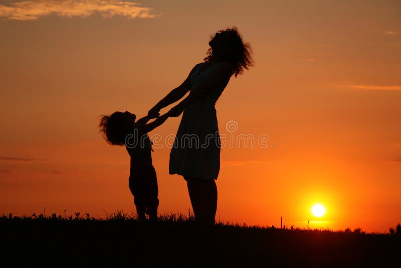 Mutter und Tochter auf Sonnenuntergang überwachend auf Himmel
