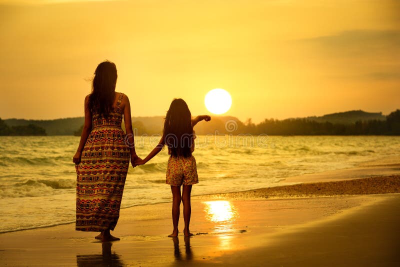 Mutter und Tochter, die auf dem Strand stehen