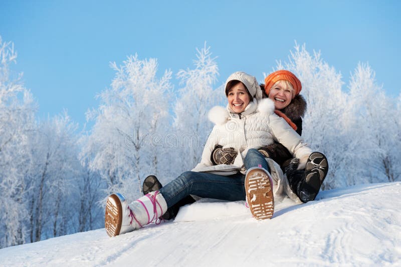 Picture of a Mother and daughter sliding in the snow. Picture of a Mother and daughter sliding in the snow