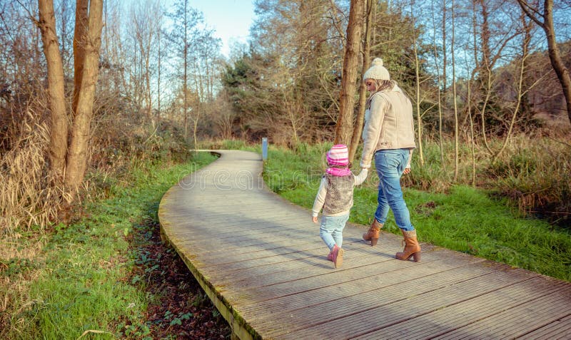 Mutter und Tochter, die zusammen Händchenhalten gehen lizenzfreie stockfotografie Mutter und Tochter, die zusammen Händchenhalten gehen lizenzfreie stockfotografie
