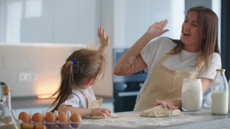 Mutter und Tochter haben, in der Küche kochen und fünf Zwiebeln. Vorschlagen von fünf. ein Klatschen auf den Händen. Kochen stock video footage