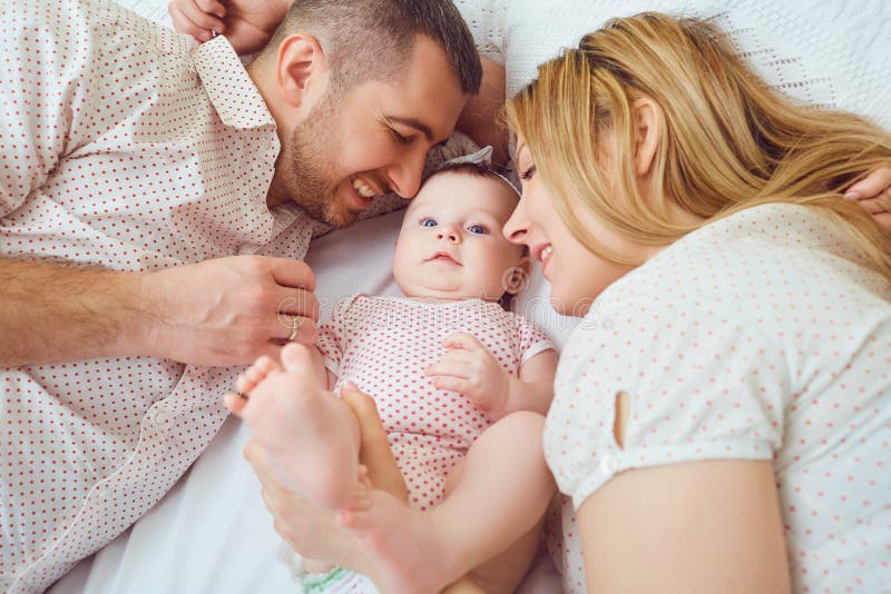Mutter und Vater spielen mit dem Baby auf dem Bett stockbilder Mutter und Vater spielen mit dem Baby auf dem Bett stockbilder