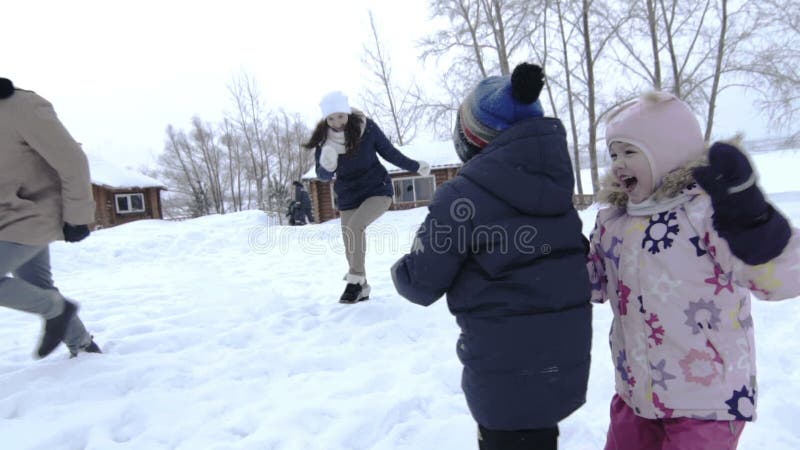 Mutter, Vater und zwei Kinderhavinf Spaß im Schnee