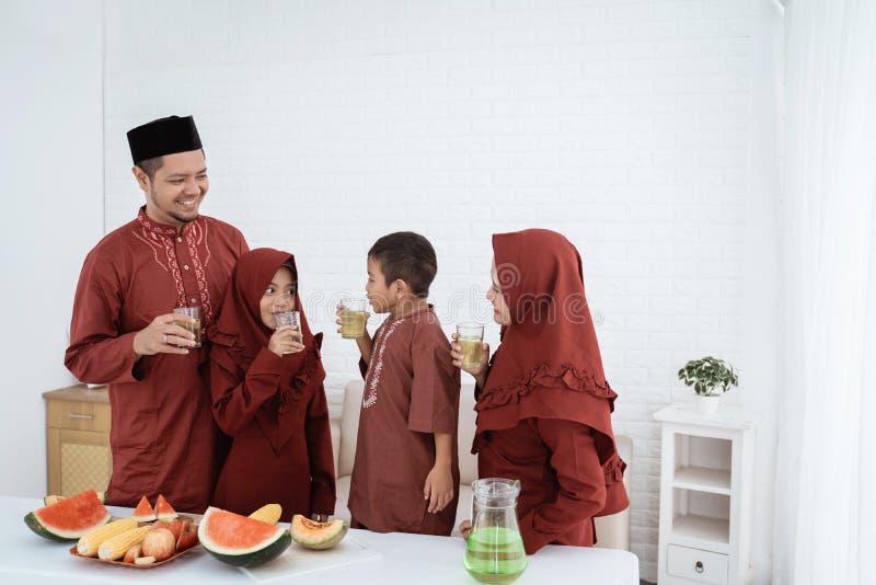 Muslim family stand to drink when breaking fast together at home. Muslim family stand to drink when breaking fast together at home