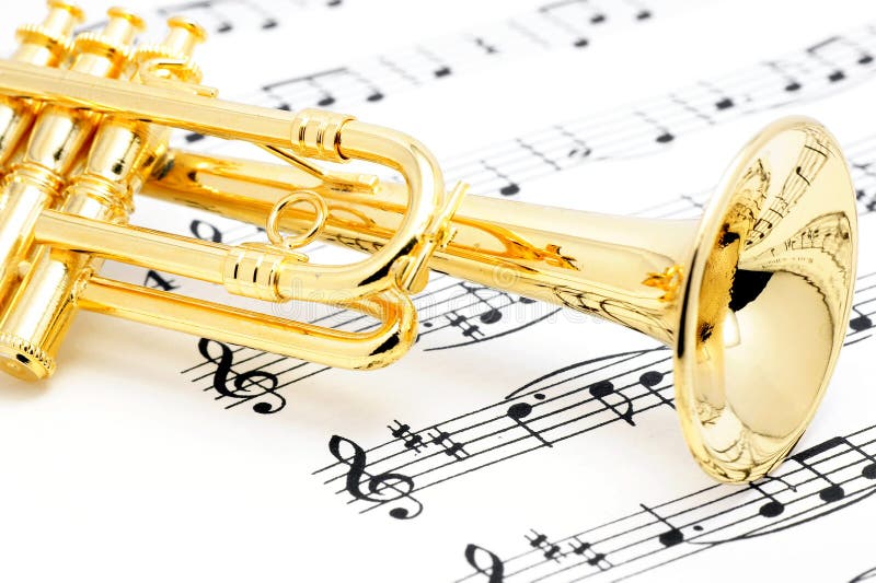 Golden trumpet lying on a musical score.(Model of musical instruments). Golden trumpet lying on a musical score.(Model of musical instruments)
