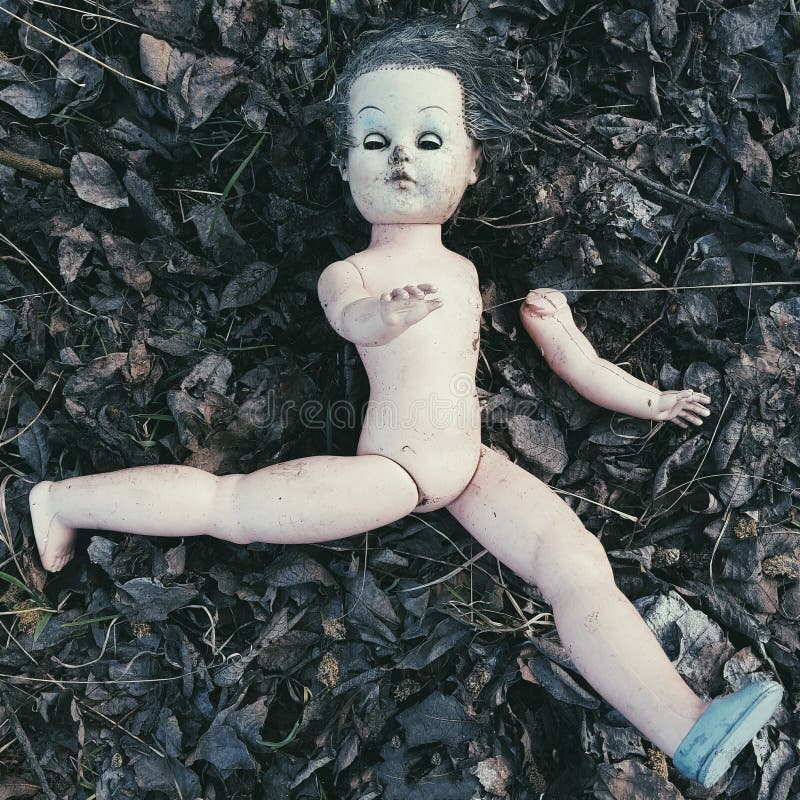 Muñeca quebrada en el de tierra - Halloween espeluznante fotografía de archivo Muñeca quebrada en el de tierra - Halloween espeluznante fotografía de archivo