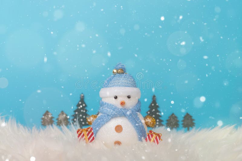 Muñeco de nieve feliz que se coloca en fondo azul de la nieve de la Navidad del invierno Paisaje de la Navidad con los regalos y fotografía de archivo Muñeco de nieve feliz que se coloca en fondo azul de la nieve de la Navidad del invierno Paisaje de la Navidad con los regalos y fotografía de archivo