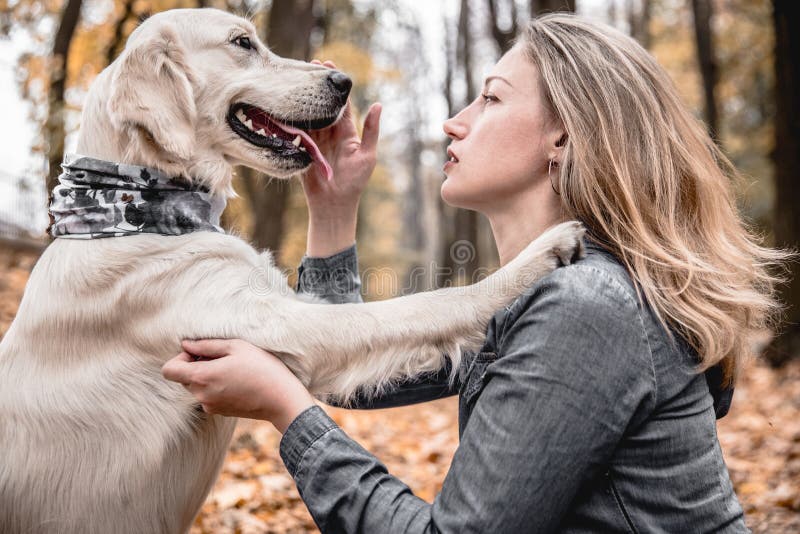 My best friend.Portrait of beautiful woman stroking the dog in the autumnal park