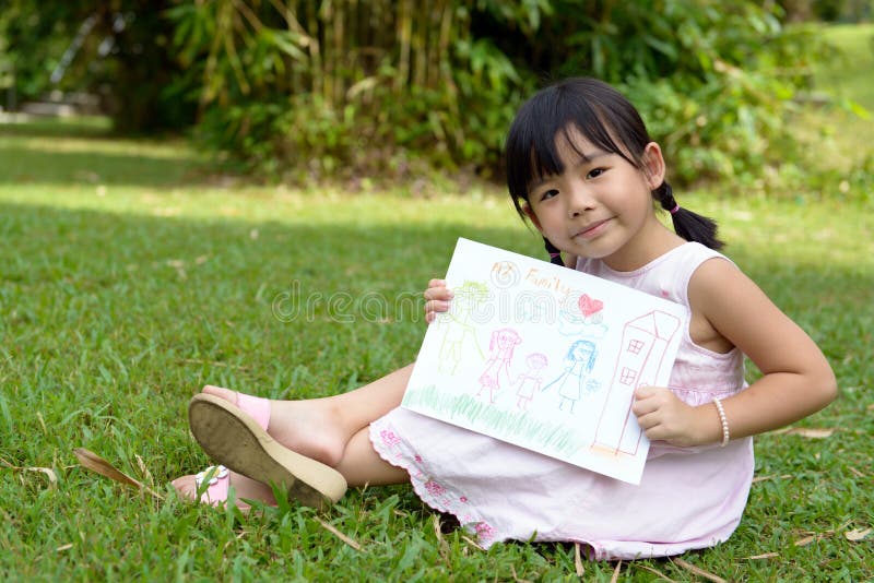 Little child shows drawing of her family member. Little child shows drawing of her family member