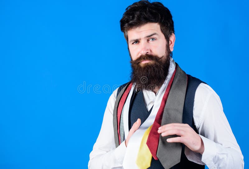 My wardrobe is stylish yet professional. Bearded man choosing a necktie essential of his wardrobe. Stylish mens wardrobe for business or formal occasions. Building a necktie wardrobe, copy space.