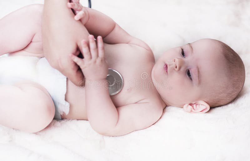 Mycket ett småbarn, behandla som ett barn, ligger tillbaka på doktorns kontor, och doktorn lyssnar till lungorna royaltyfri fotografi Mycket ett småbarn, behandla som ett barn, ligger tillbaka på doktorns kontor, och doktorn lyssnar till lungorna royaltyfri fotografi