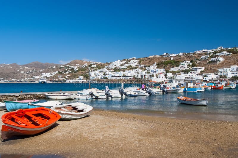 Mykonos, Grécia - 4 de maio de 2010: barcos na praia do mar Vila com as casas brancas no mar azul na paisagem da montanha verão fotografia de stock Mykonos, Grécia - 4 de maio de 2010: barcos na praia do mar Vila com as casas brancas no mar azul na paisagem da montanha verão fotografia de stock