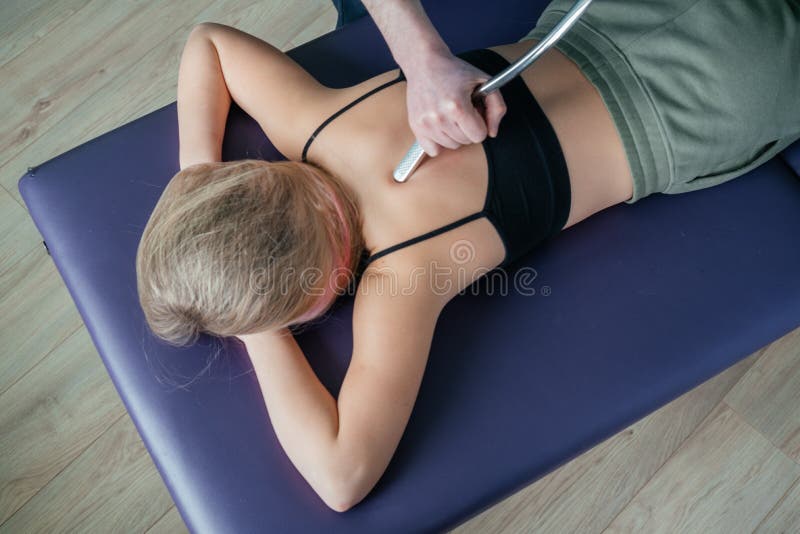 Myofascial release therapy of back pain using stainless steel IASTM tool royalty free stock photo