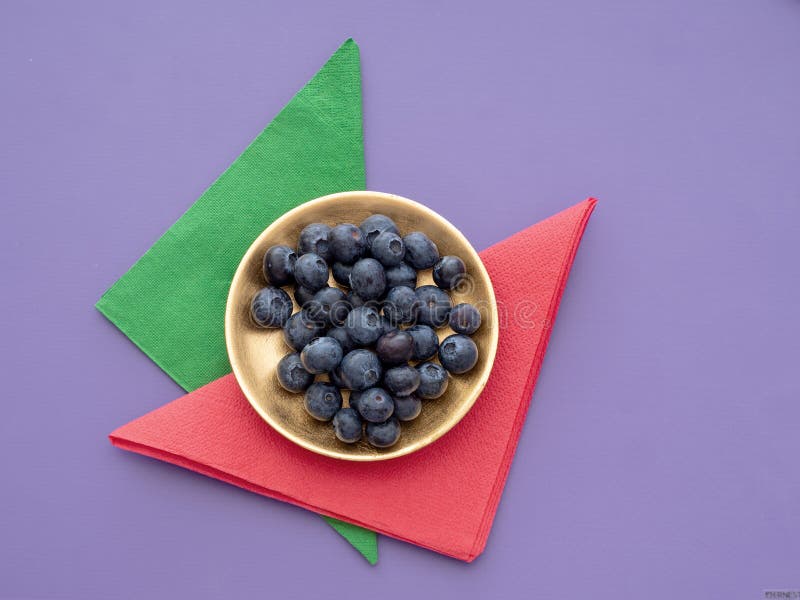 Myrtilles saines de superfood sur le fond coloré avec les serviettes de papier, les serviettes et la fine couche d'or images stock Myrtilles saines de superfood sur le fond coloré avec les serviettes de papier, les serviettes et la fine couche d'or images stock