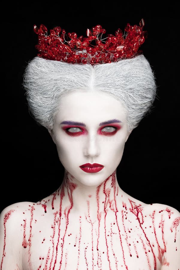 Mysterious beauty portrait of snow queen covered with blood. Bright luxury makeup. White demon eyes. stock photos Mysterious beauty portrait of snow queen covered with blood. Bright luxury makeup. White demon eyes. stock photos