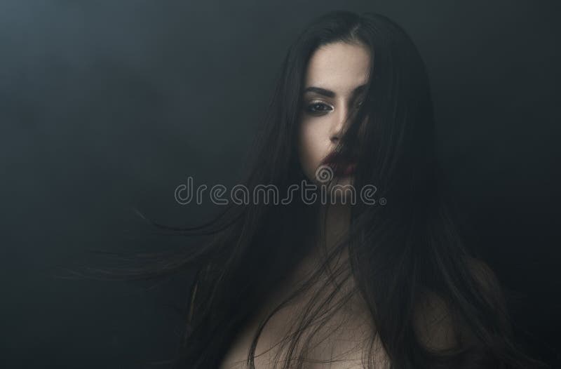 Mysterious portrait of a girl in dark fog