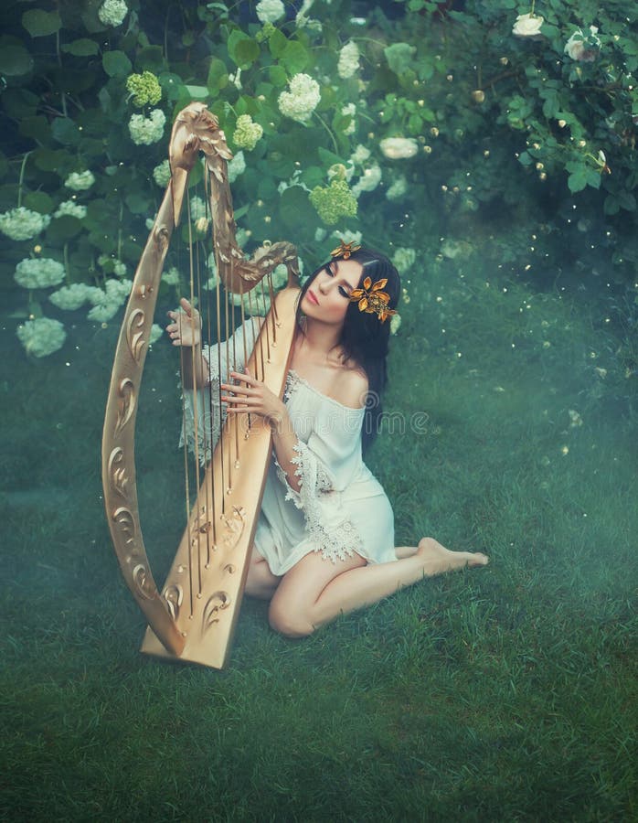 Mysterious spirit of the forest plays on a golden fairy harp